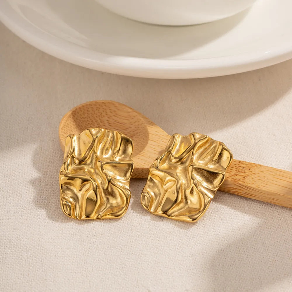 Gold geometric square stud earrings on model