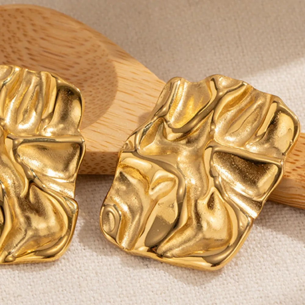 Close-up detail of 18K gold-plated square studs